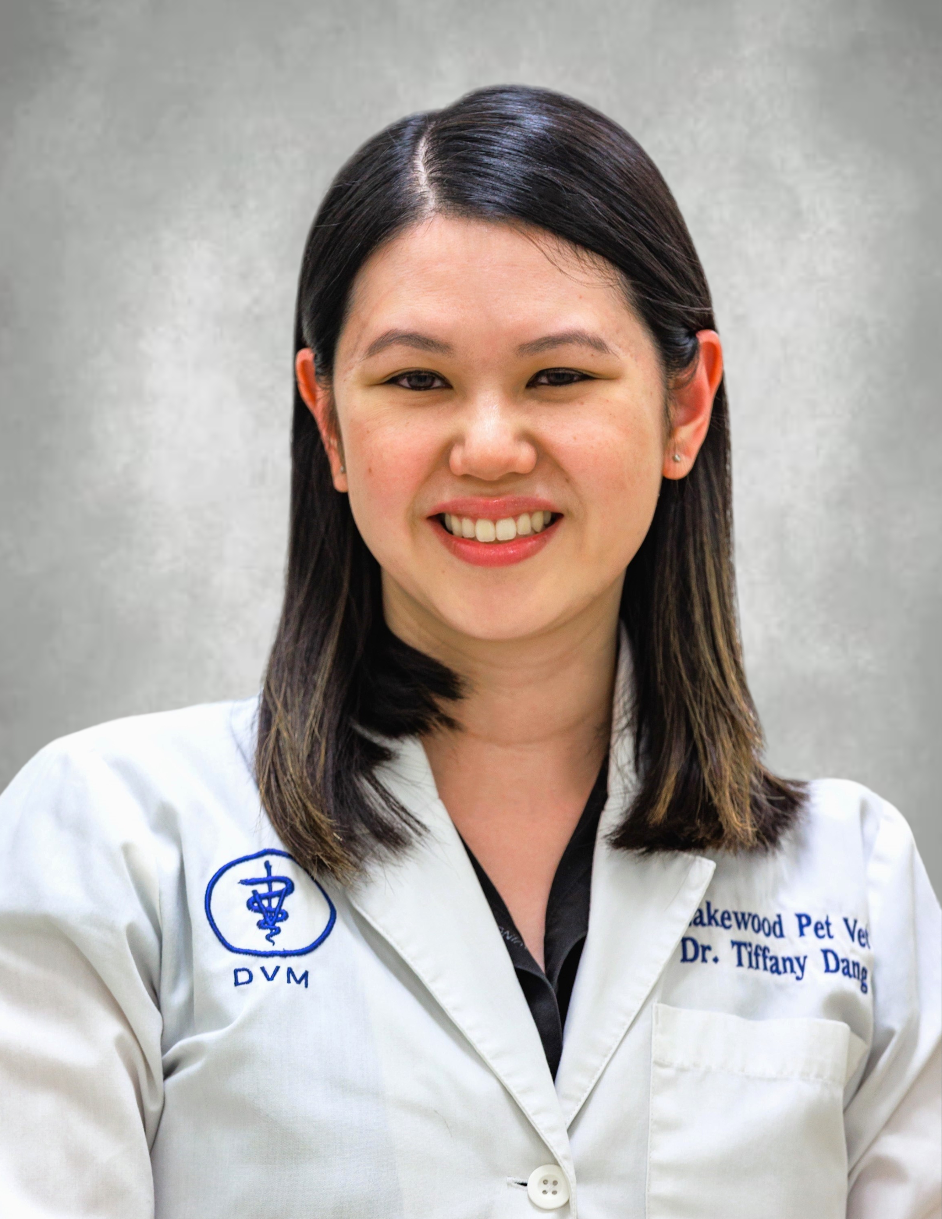 Dr. Dang smiling in her lab coat